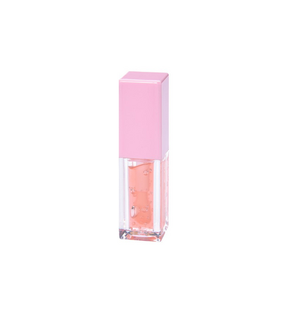 Tube of Pheromones lip gloss with a pink cap and a passionfruit-orange gloss inside, standing on a white background.